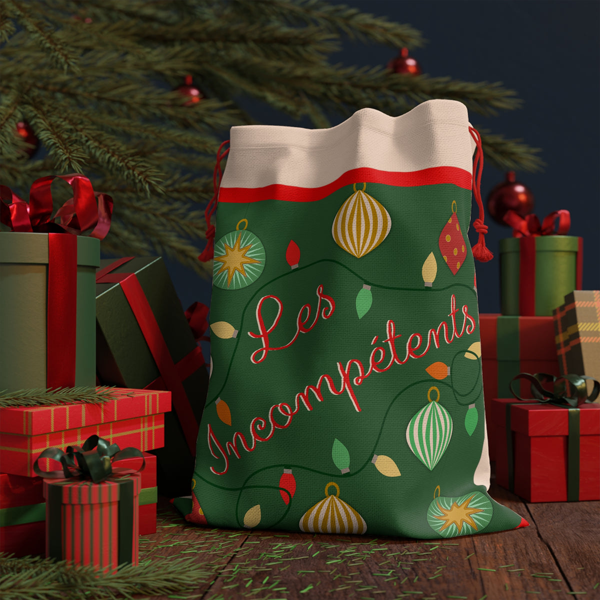Les Incompétents Christmas gift bag under the tree with wrapped presents